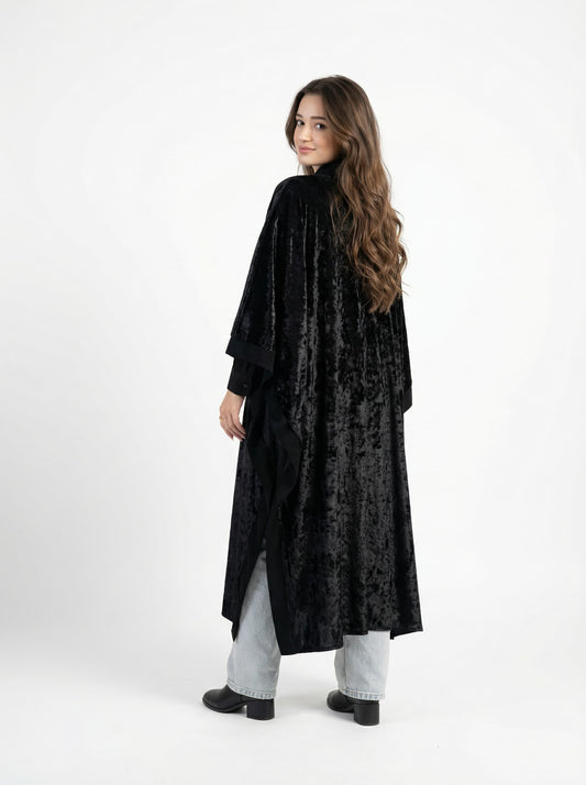 Woman wearing a black textured long coat on a white background