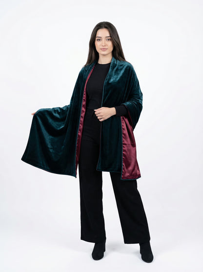 Woman wearing a dark green coat with red lining on a white background