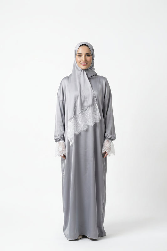 Woman wearing a gray abaya with a matching hijab on a white background
