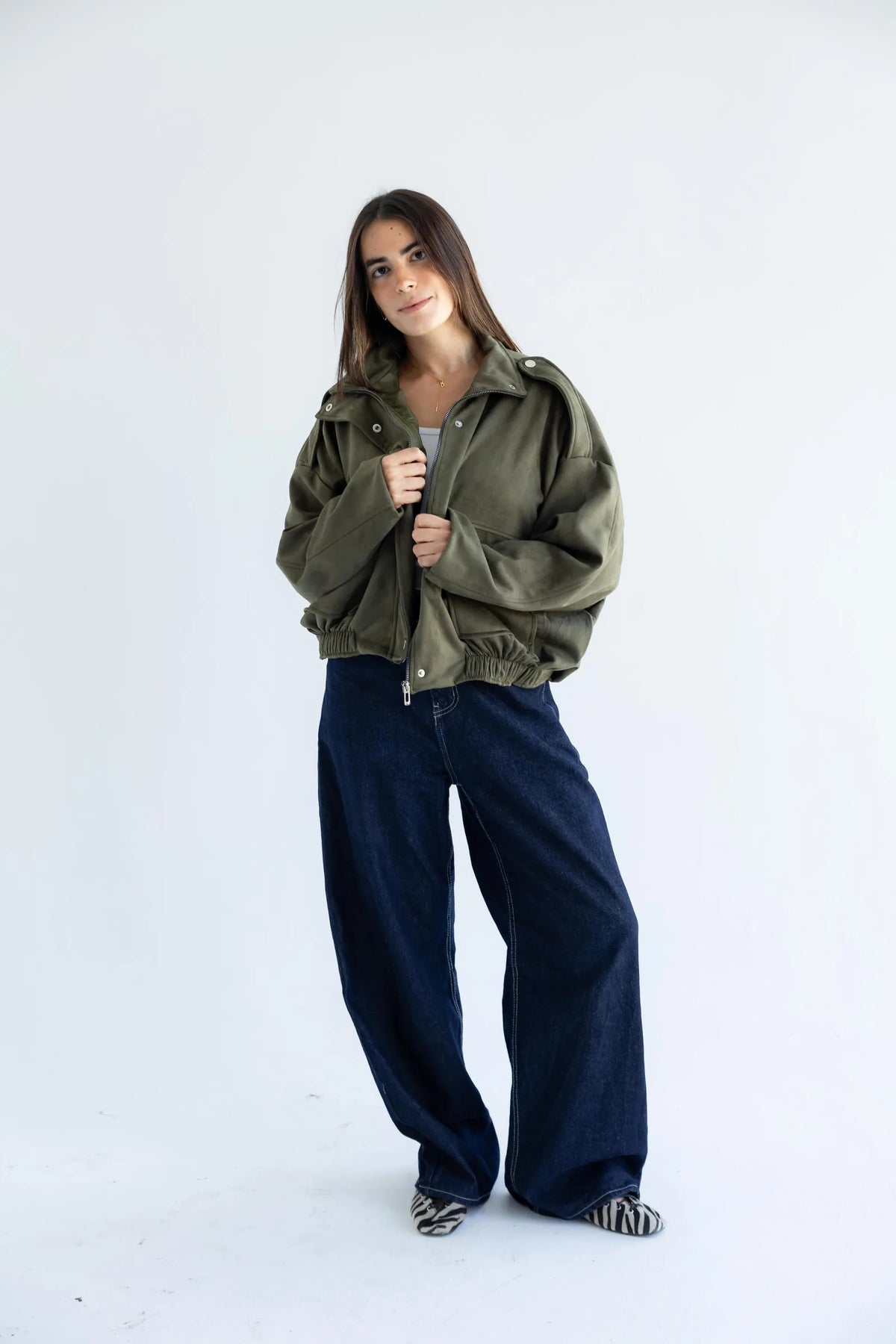 Olive green utility bomber jacket with dark wide-leg jeans - full length