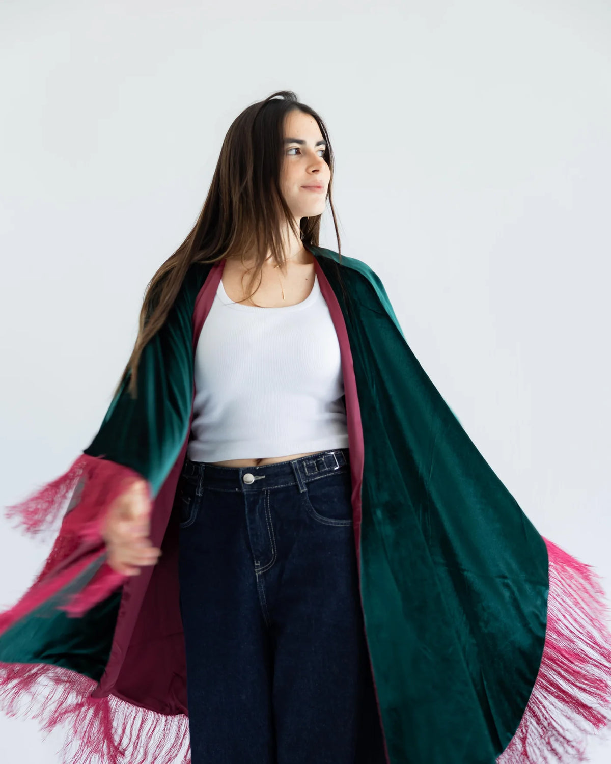 Emerald velvet cape with fuchsia fringe in motion